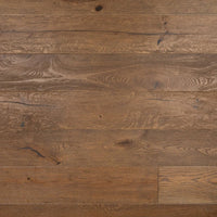 Medium brown hardwood flooring planks with visible natural grain, knots, and wood texture.