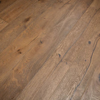 Medium brown hardwood flooring planks with visible natural grain patterns and knots.