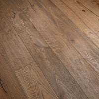Rustic medium-brown hardwood flooring planks with visible natural grain, knots, and weathered texture.