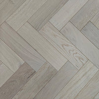 Light oak herringbone parquet flooring with a natural wood grain finish.