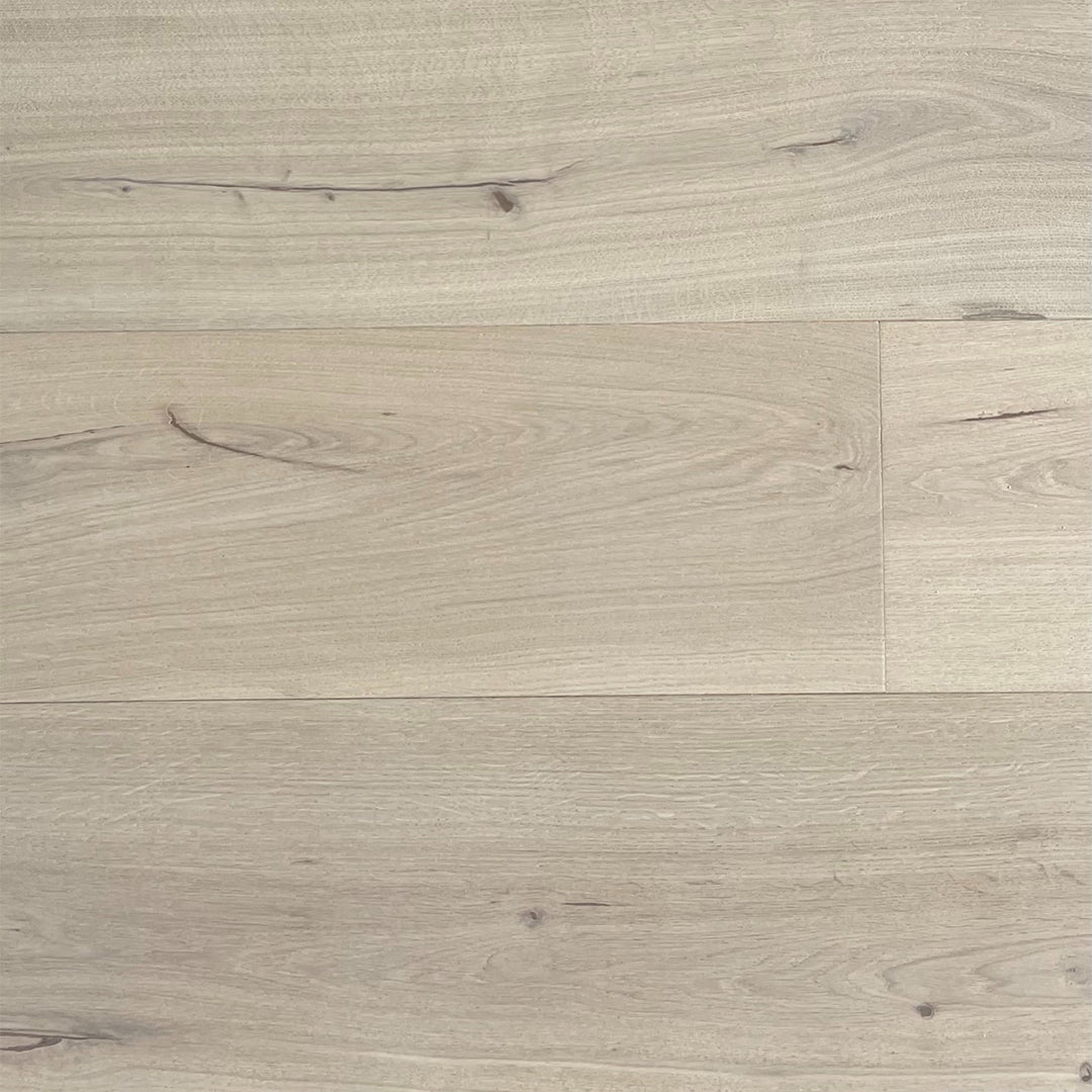 Light oak wood flooring planks with visible grain, knots, and natural texture in a pale beige-gray tone.