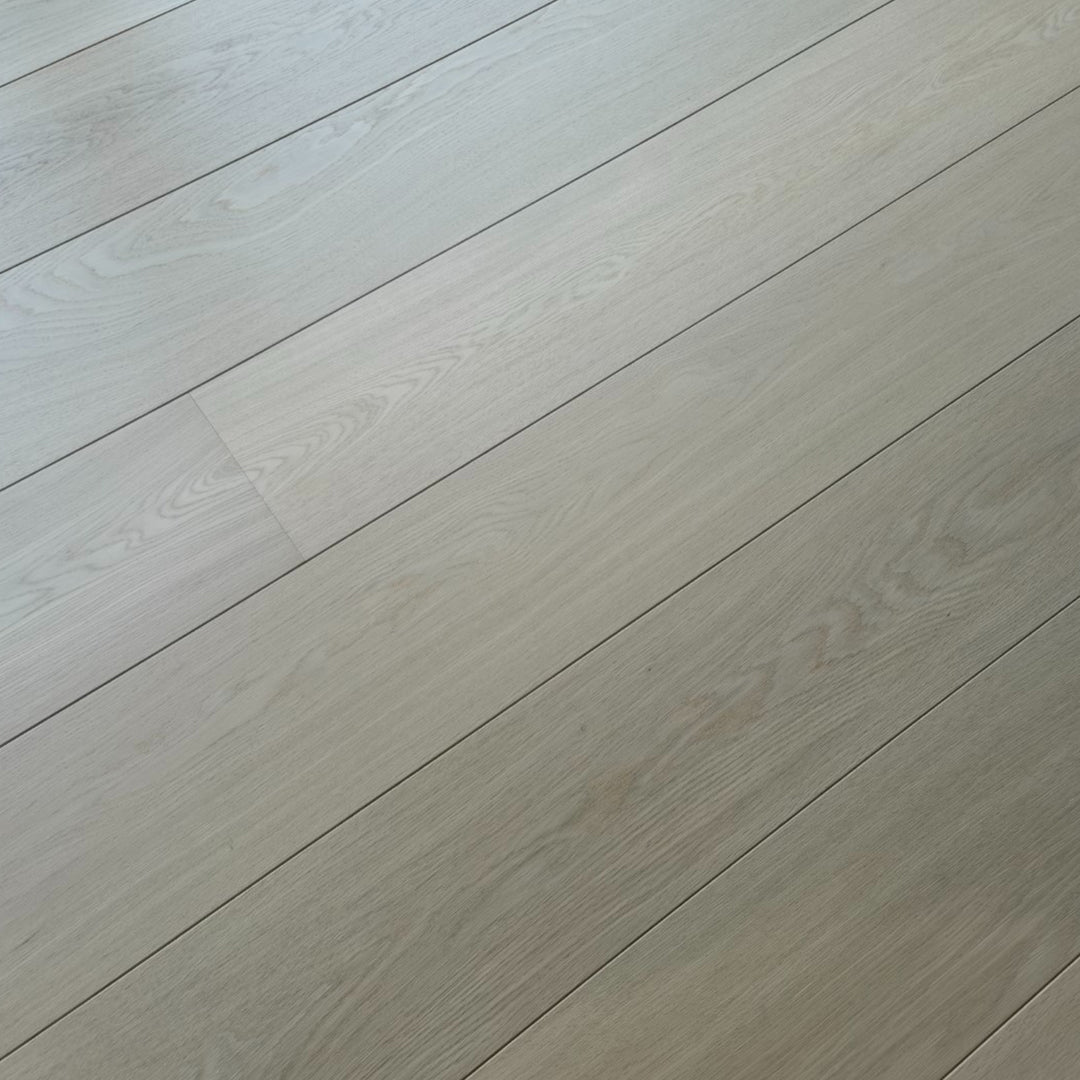 Light beige wood flooring planks with a subtle grain texture, arranged diagonally across the frame.