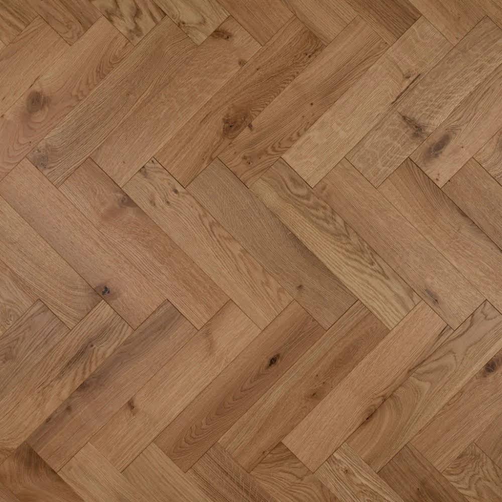 Herringbone parquet flooring in a warm medium brown wood finish, showing natural grain and knots.